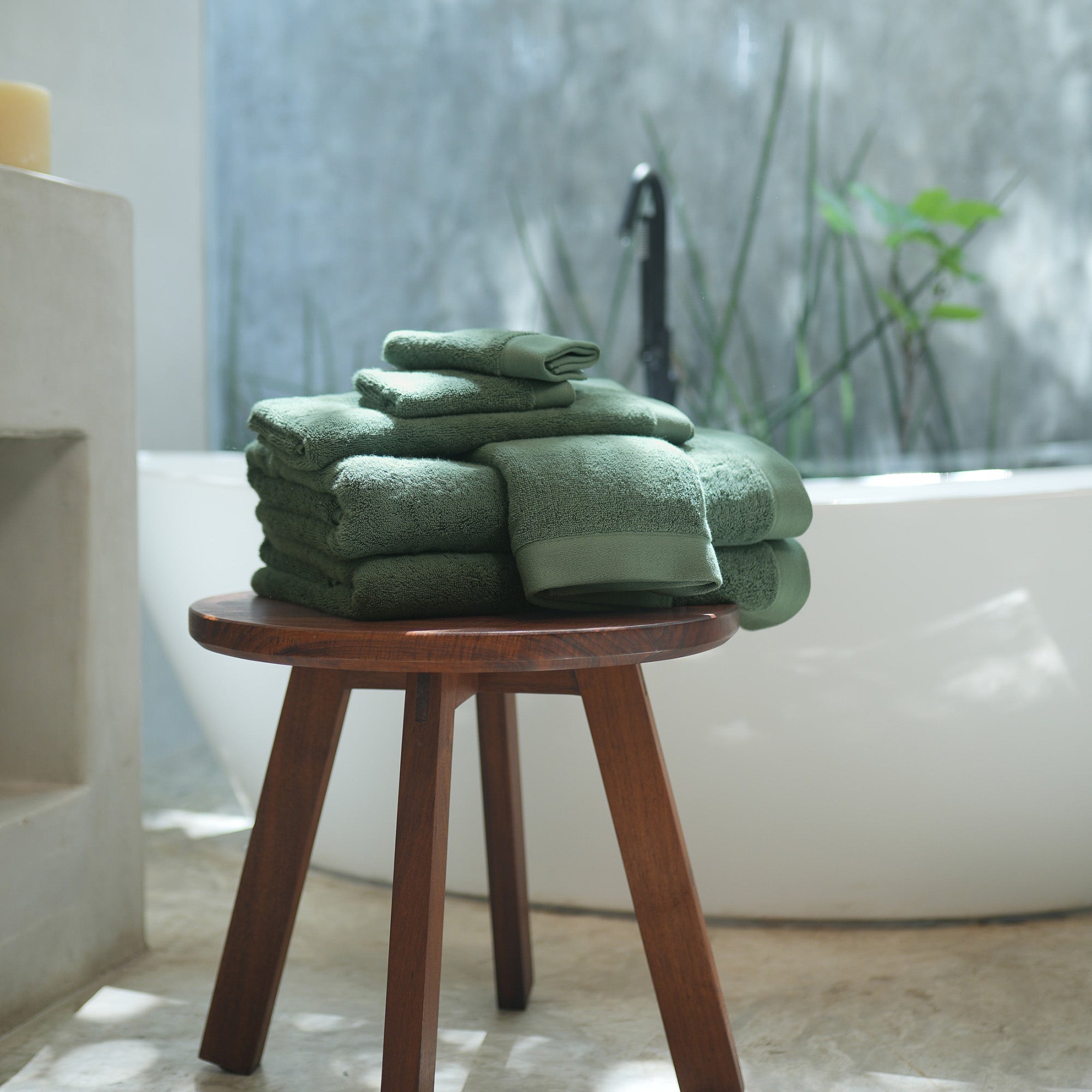 Oasis Bath Towel Set by Rest & Reset styled on a wooden stool, combining functionality with spa-like comfort