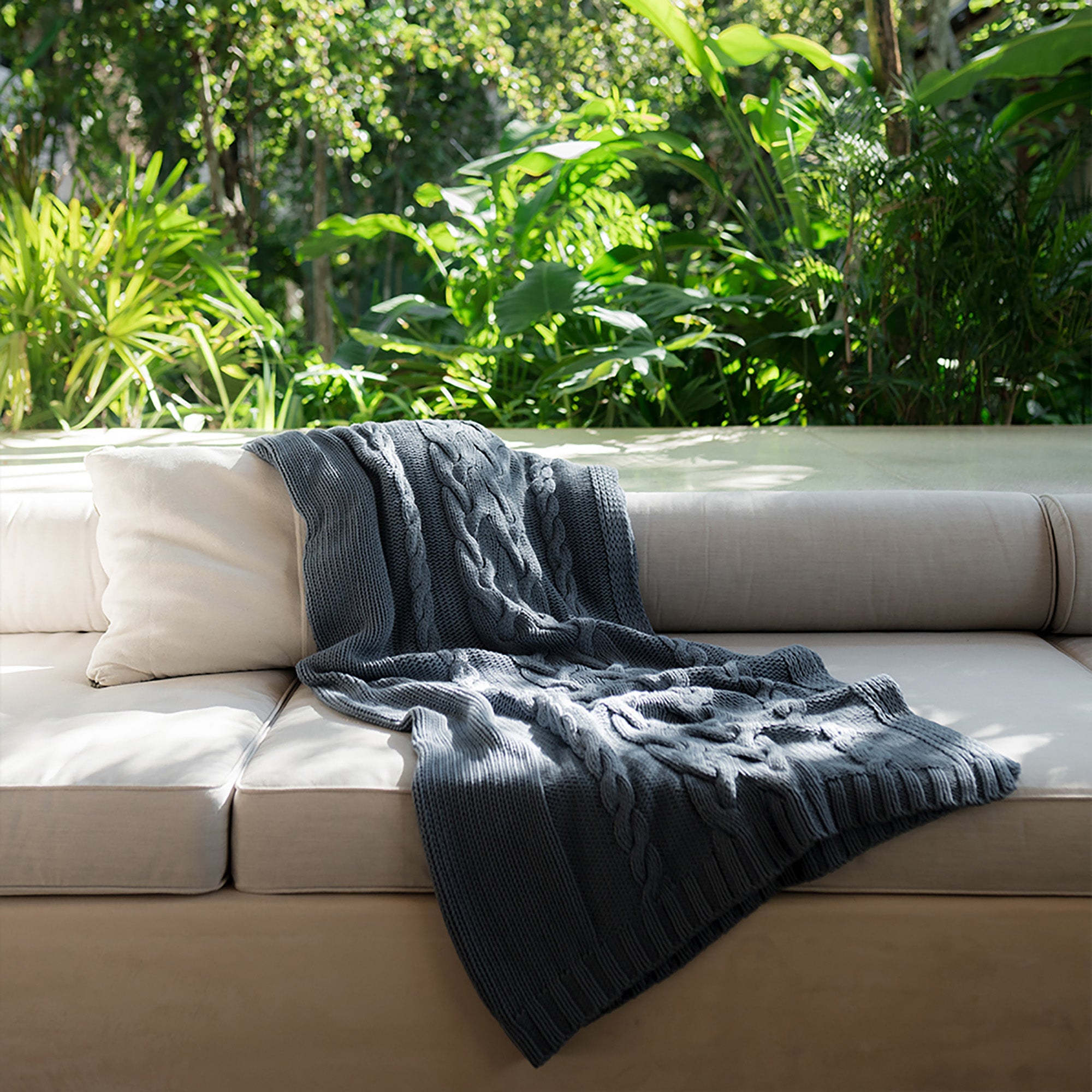 Drift Throw Blanket by Rest & Reset styled on outdoor furniture, adding warmth and texture to the space