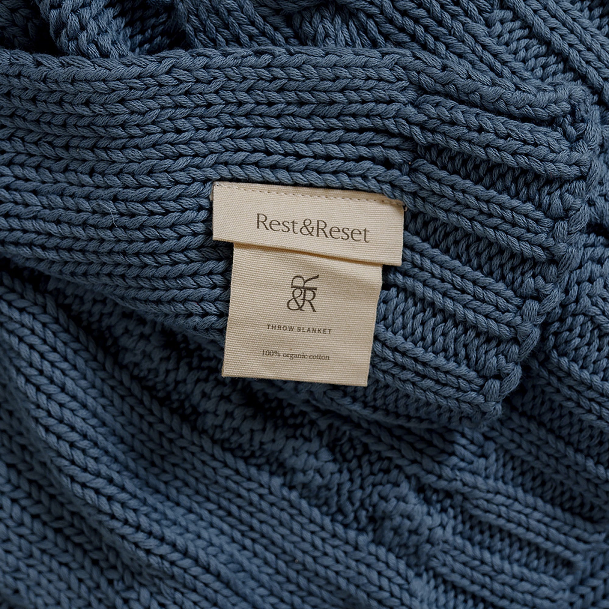 Close-up of label on Drift Throw Blanket by Rest & Reset, emphasizing craftsmanship and premium materials